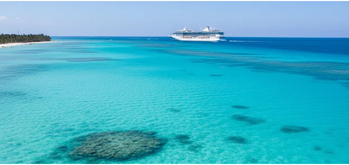 A vessel sailing across clear turquoise sea water